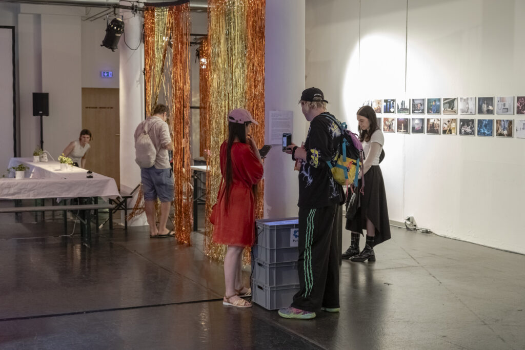 Tinsel curtains and visitors at an exhibition.
