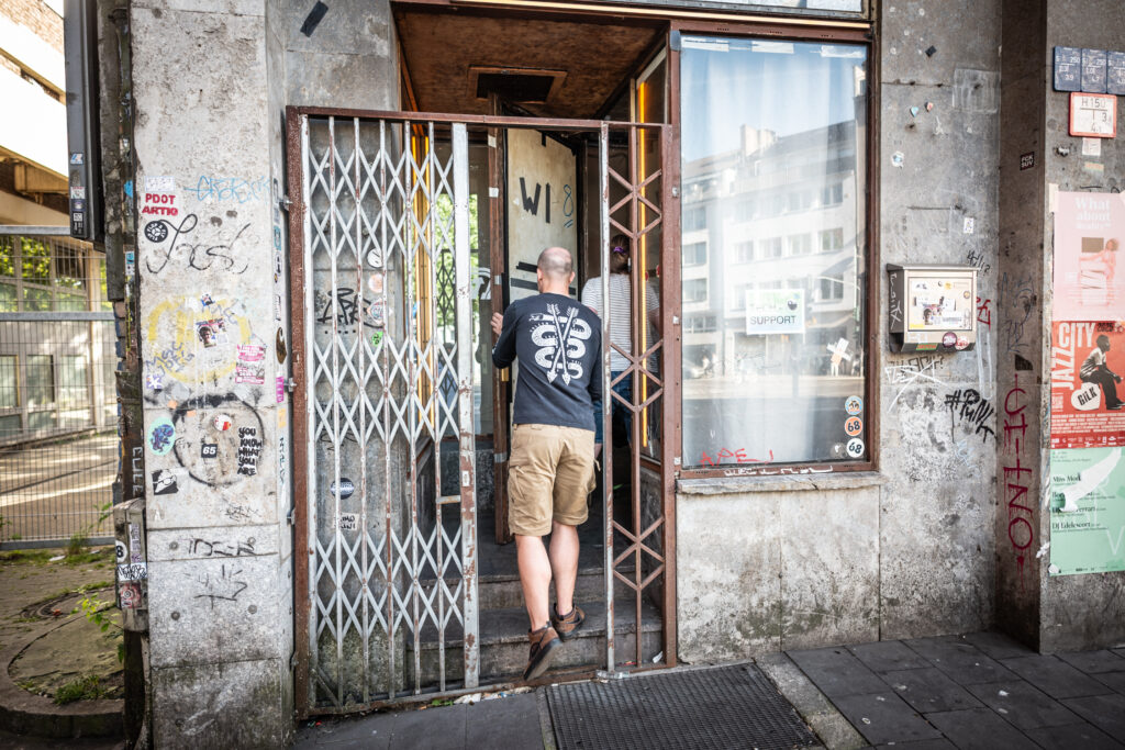 A person enters a rancid-looking house entrance.