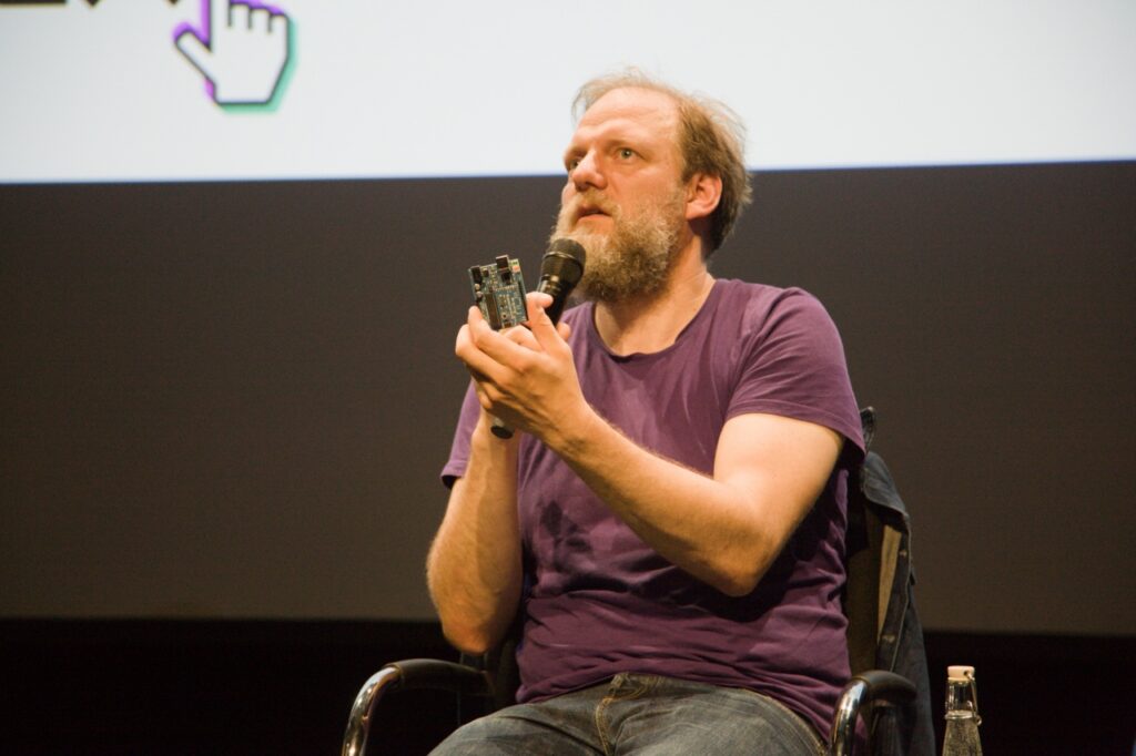 Georg Werner is sitting and speaking into a microphone.
