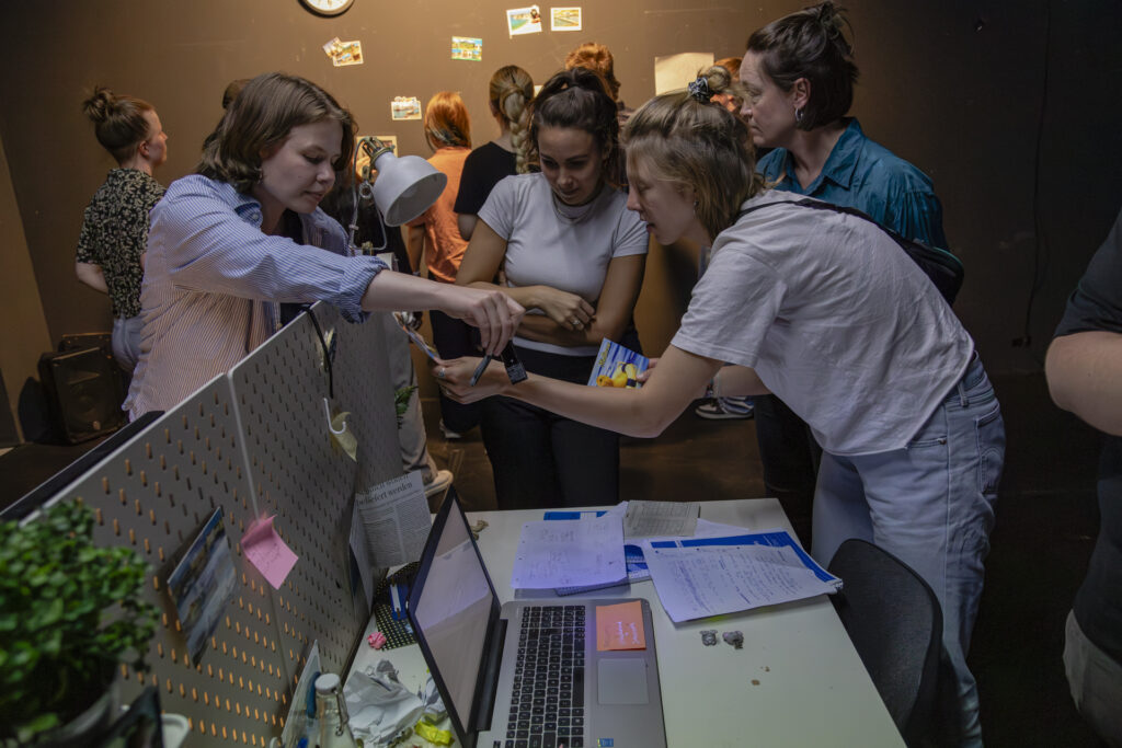 Several people are searching through a desk.
